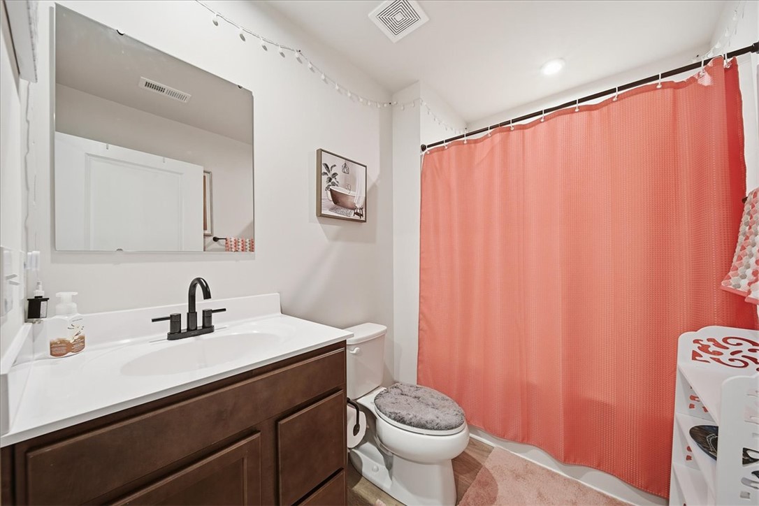 117 Alice Court Easley, SC 29642 - Photo 15 of 26 A well-appointed bathroom features a dark wood vanity with white countertop and a convenient shower area.