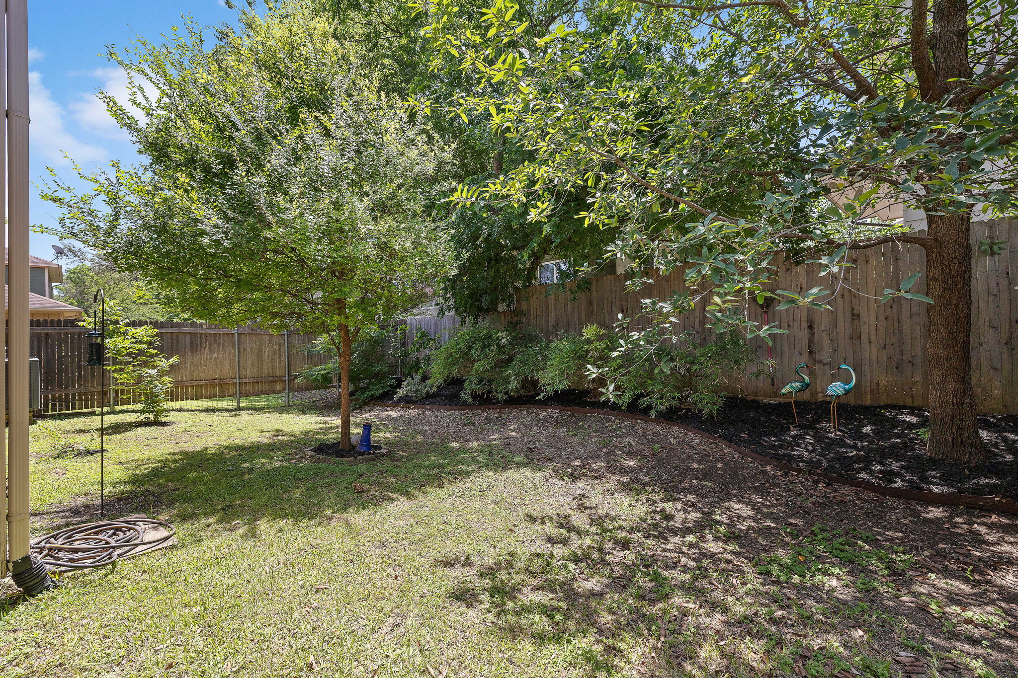 6708 Menchaca Road, Unit 10 Austin, TX 78745 - Photo 27 of 28 Expansive backyard featuring a manicured lawn, established trees, and a privacy fence