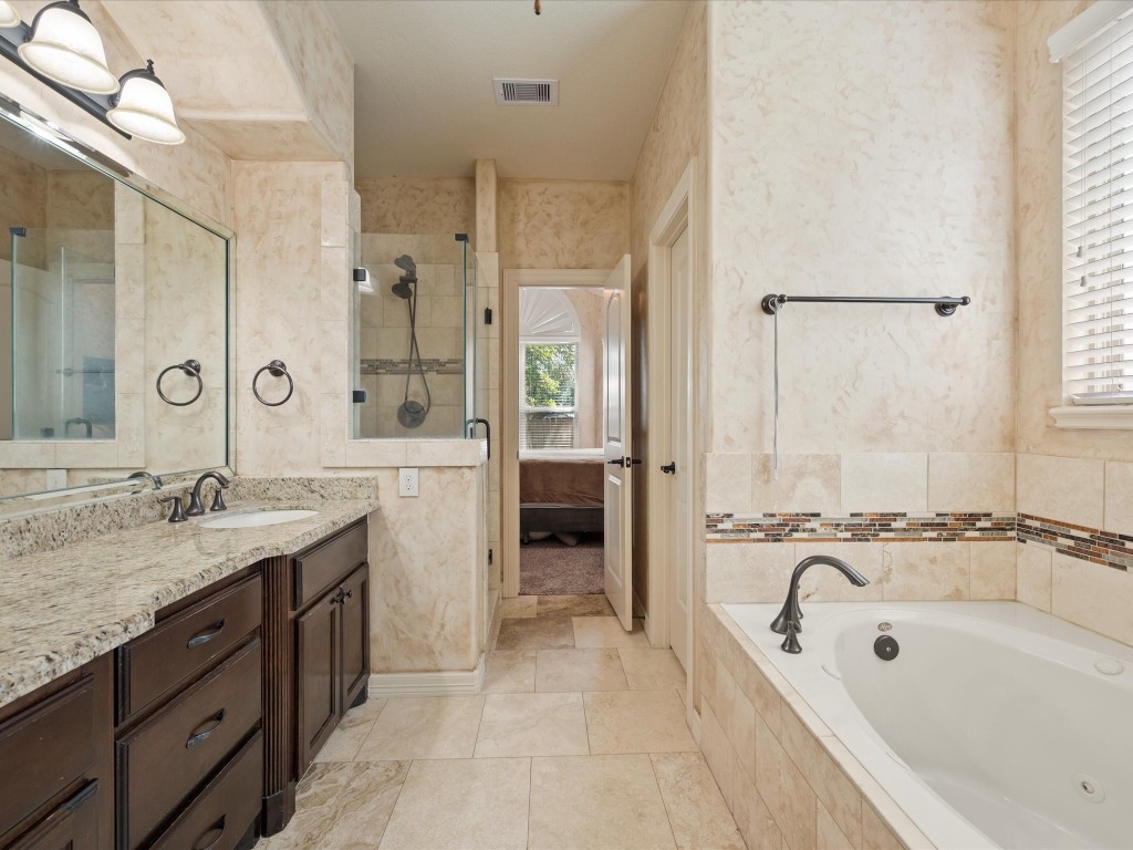 763-806 Lake View Drive Montgomery, TX 77356 - Photo 21 of 43 Primary Bathroom with dual vanities, matching custom wood cabinetry, high-end granite countertops.