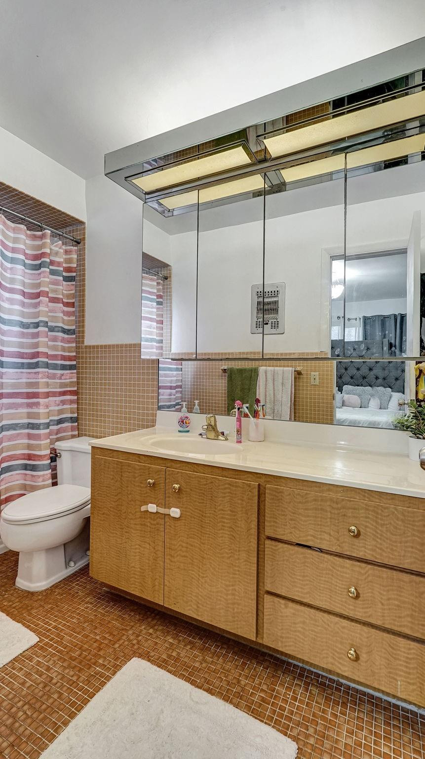 3410 Cleveland Street Hollywood, FL 33021 - Photo 28 of 63 a bathroom with a double vanity sink a mirror and a bathtub