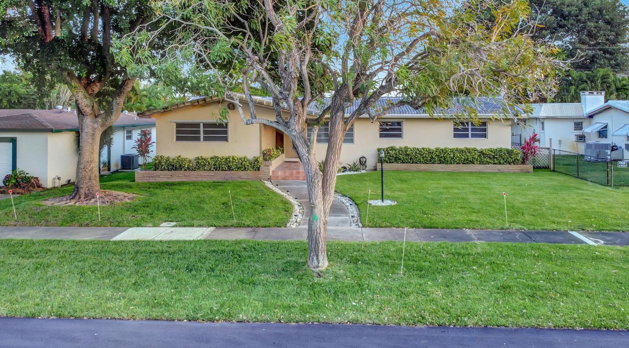 3410 Cleveland Street Hollywood, FL 33021 - Photo 50 of 63 a front view of a house with a yard and a large tree