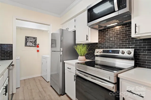 a kitchen with stainless steel appliances and white cabinets