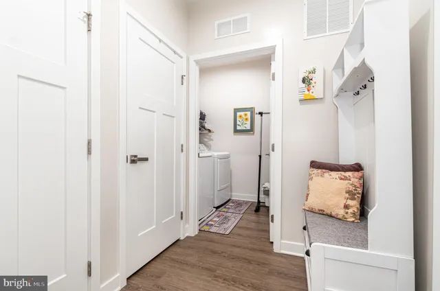 a hallway with wooden floor and a bathroom