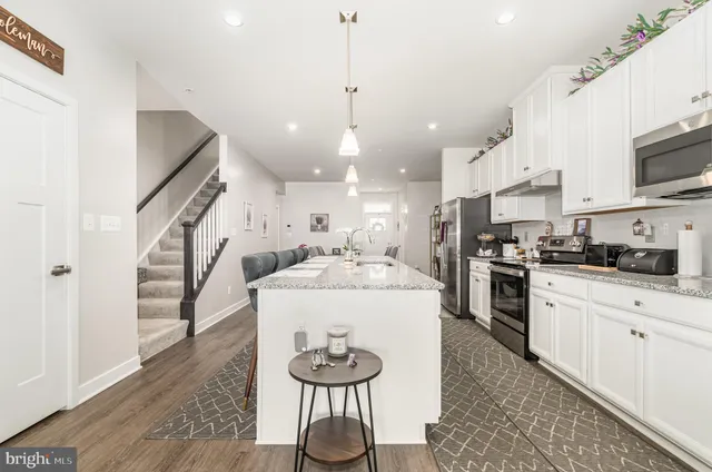 a kitchen with stainless steel appliances granite countertop a sink stove and wooden floor