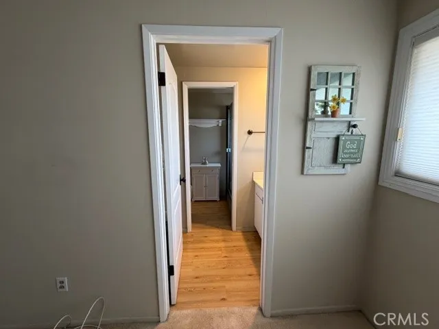 a view of a hallway with wooden floor and a livingroom