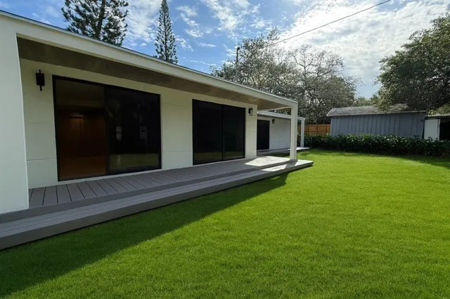 a view of a backyard with table and chairs and wooden fence