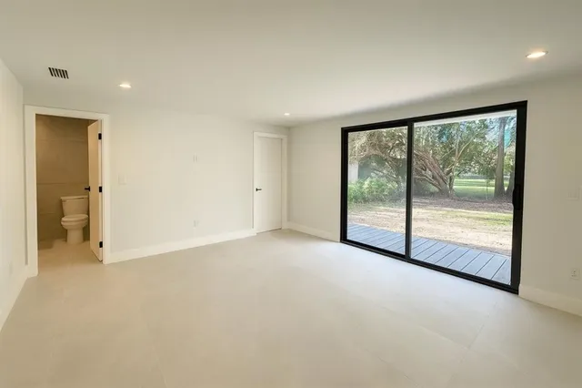 an empty room with large windows and a balcony