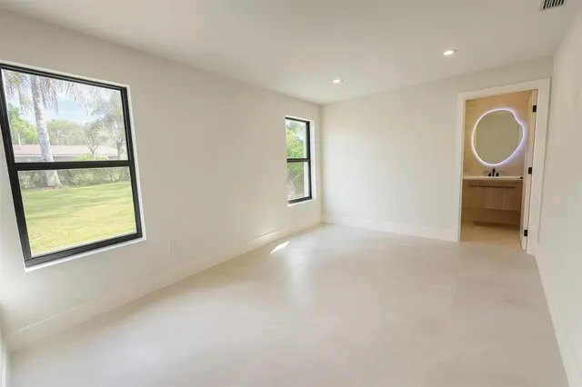 a view of an empty room with a window and a mirror