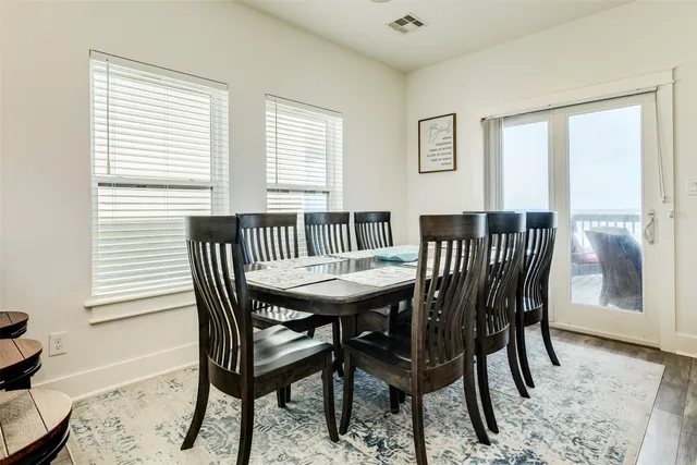 a view of a a dining room with furniture window and wooden floor
