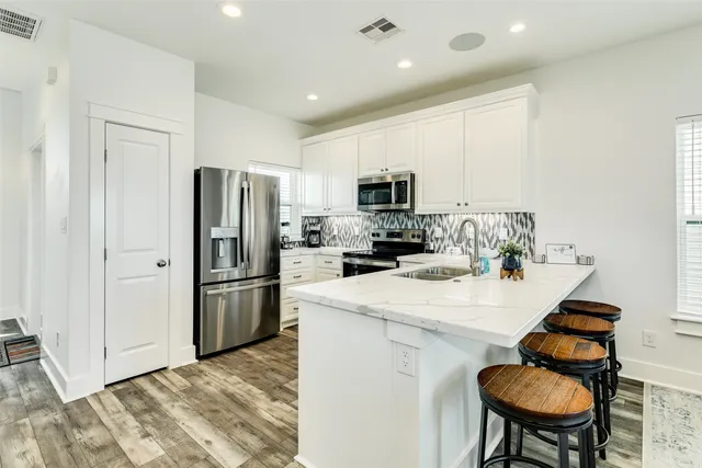 a kitchen with white cabinets sink and stainless steel appliances