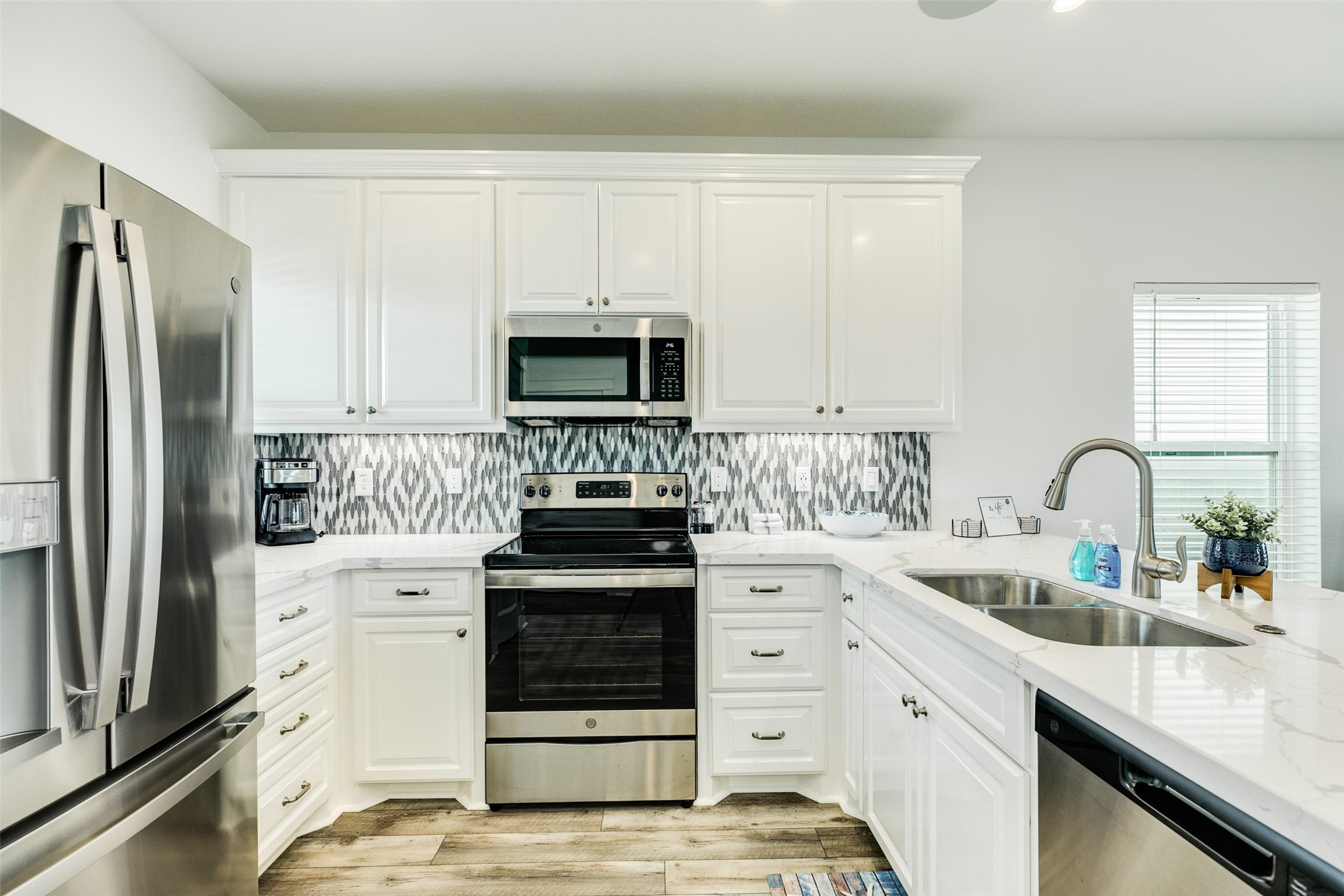 109 D Santar Loop Surfside Beach, TX 77541 - Photo 17 of 42 a kitchen with white cabinets sink and stainless steel appliances