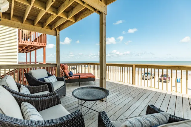 a balcony with wooden floor and outdoor seating