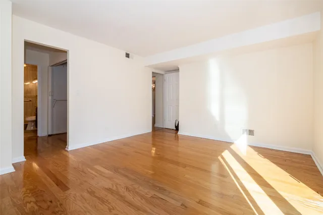 a view of an empty room with wooden floor
