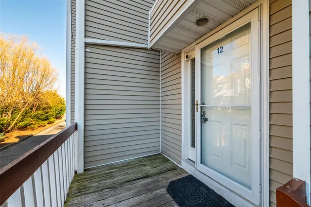 a view of a porch with wooden floor and a floor to ceiling window