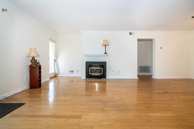 a view of a livingroom with wooden floor and a fireplace
