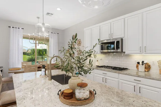 a kitchen with stainless steel appliances granite countertop a stove a sink and a white cabinets