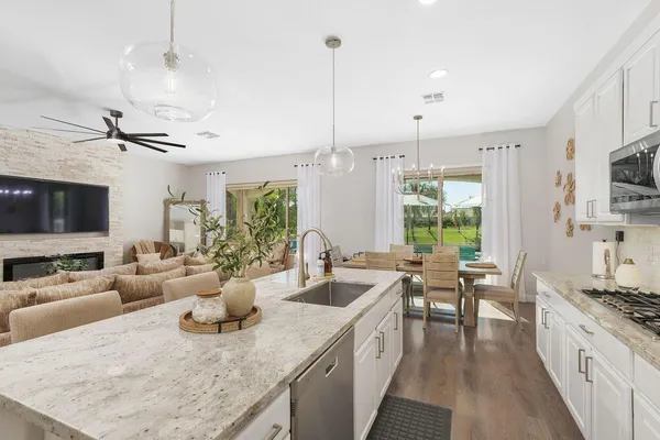 a large kitchen with kitchen island lots of counter space a sink appliances and a living room view