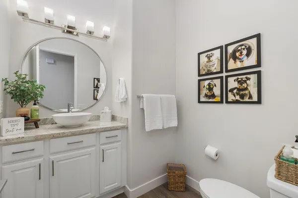 a bathroom with a granite countertop toilet sink and mirror