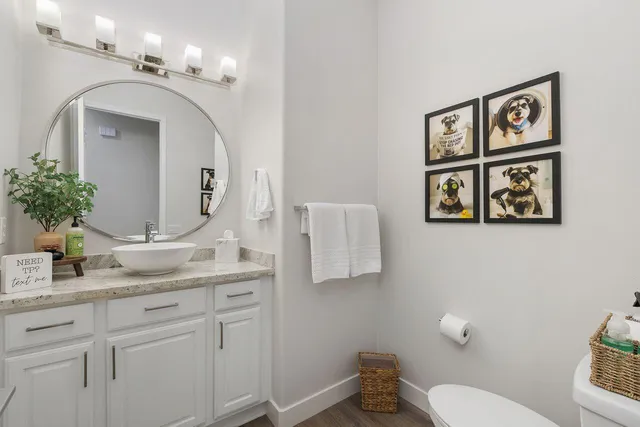 a bathroom with a granite countertop toilet sink and mirror