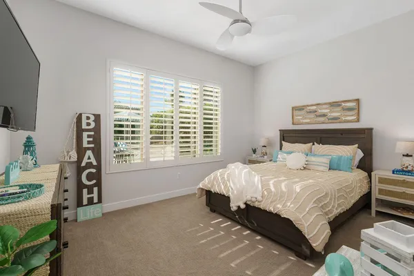 a bedroom with a bed next to a window with a bookshelf