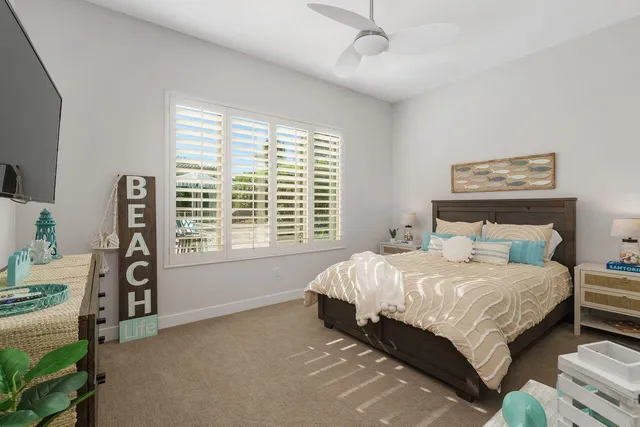 a bedroom with a bed next to a window with a bookshelf
