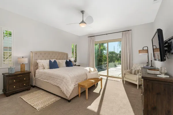 a bedroom with a bed a large window and flat screen tv