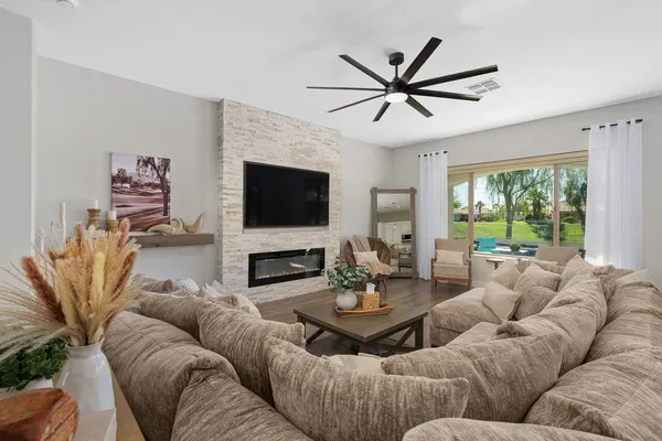 a living room with furniture a large window and a flat screen tv