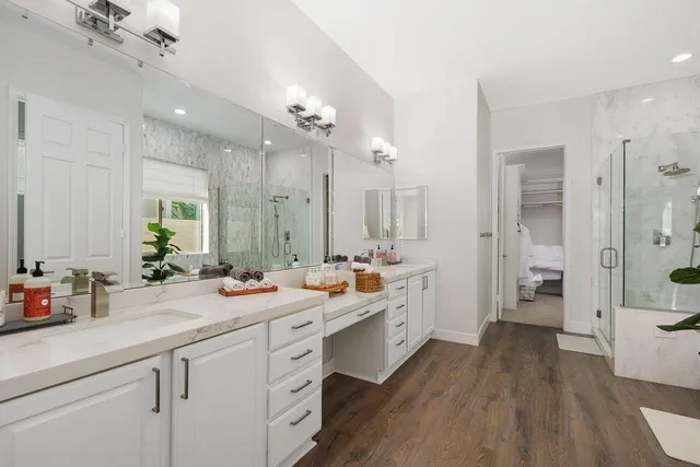 a view of a double vanity sink mirror and wooden cabinets