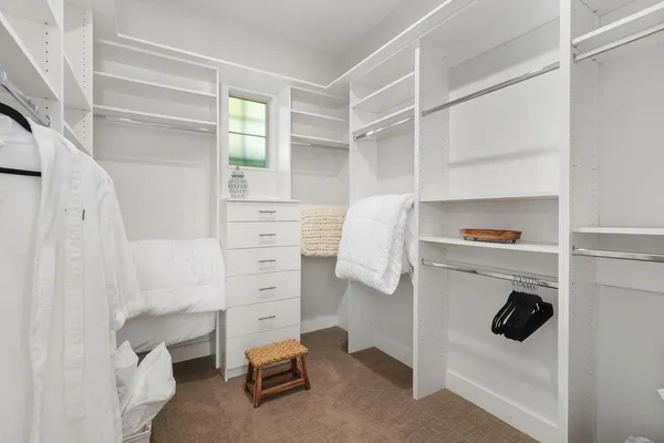 a view of walk in closet with clothes and shoes