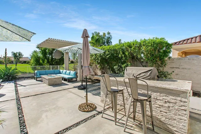 a view of a patio with table and chairs potted plants with wooden floor and fence