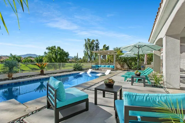 a view of swimming pool with outdoor seating and plants