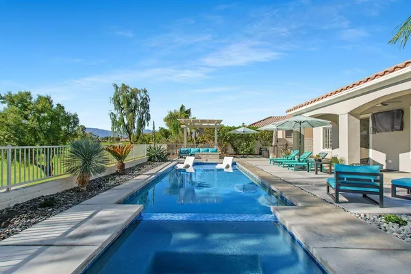 a view of a house with backyard and sitting area