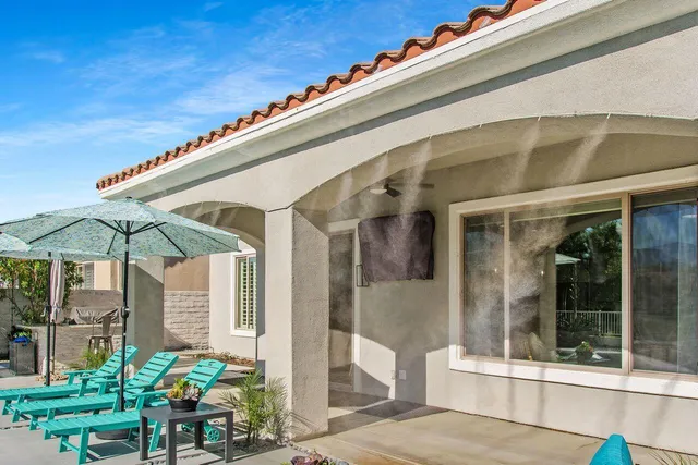 a patio with a table and chairs under an umbrella
