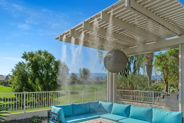 a view of a chair and tables in the back yard of the house
