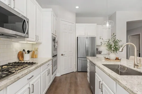 a kitchen with stainless steel appliances granite countertop a sink stove and refrigerator
