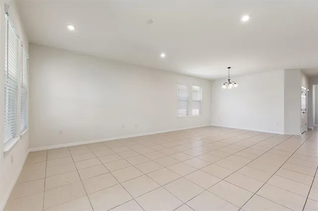 an empty room with white walls and windows