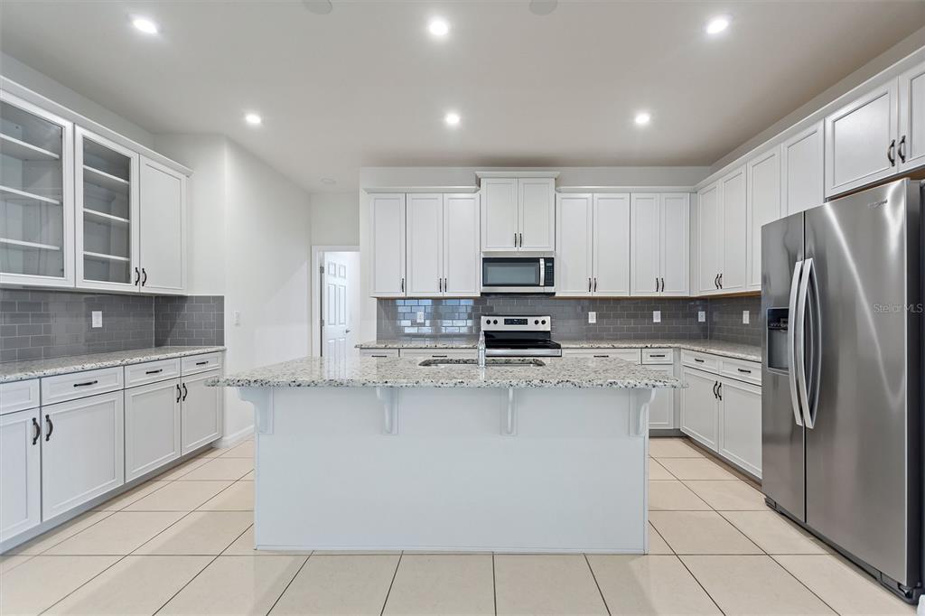 2500 Avian Loop Kissimmee, FL 34741 - Photo 16 of 35 a kitchen with stainless steel appliances granite countertop a refrigerator sink and cabinets