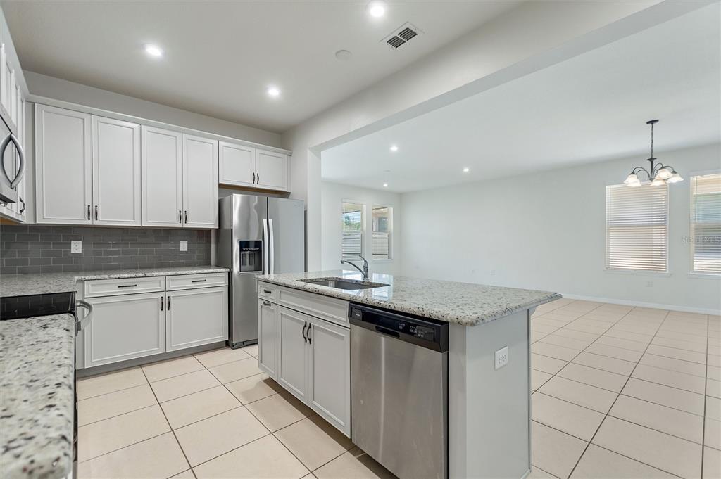 2500 Avian Loop Kissimmee, FL 34741 - Photo 18 of 35 a kitchen with a sink a refrigerator and cabinets