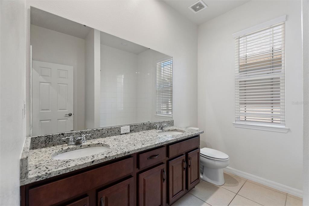 2500 Avian Loop Kissimmee, FL 34741 - Photo 5 of 35 a bathroom with a granite countertop sink toilet and mirror
