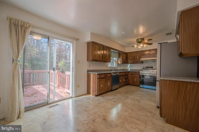 a kitchen with stainless steel appliances granite countertop a stove refrigerator and cabinets