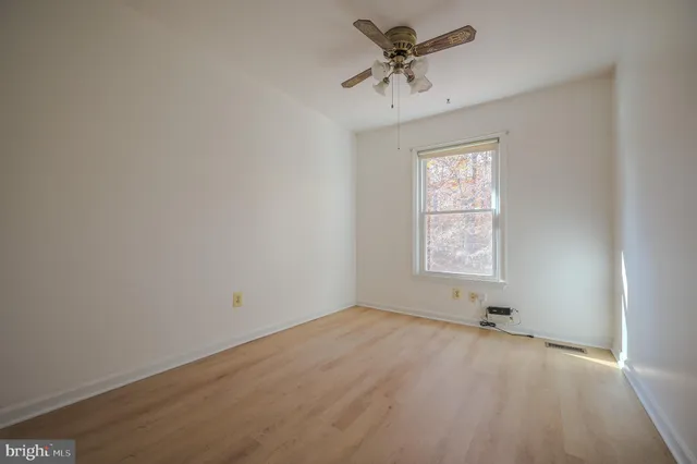 an empty room with a window and a fan