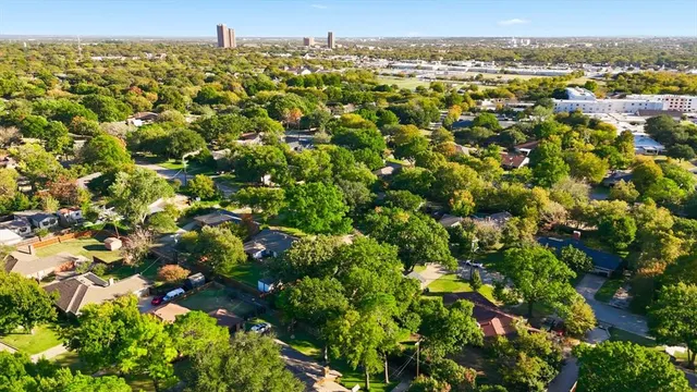 an aerial view of residential houses with outdoor space and trees