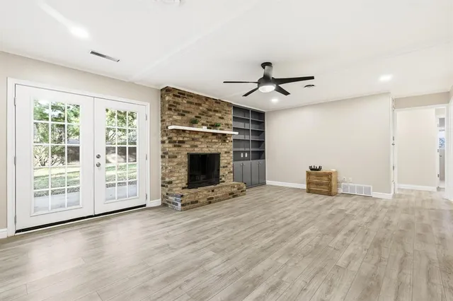 a view of an empty room with a fireplace and a window