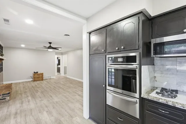 a kitchen with granite countertop a stove and stainless steel appliances