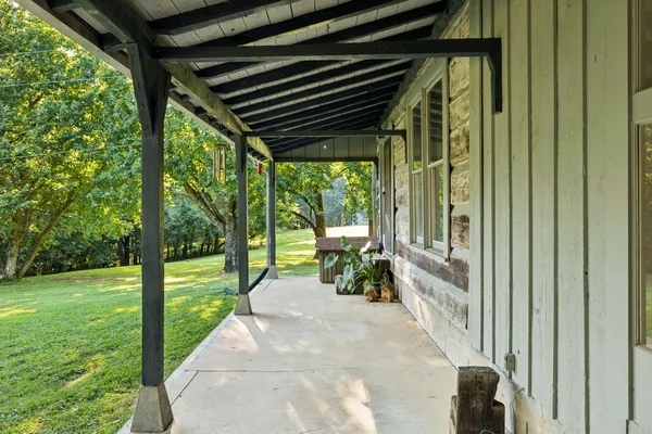 a view of a house with a yard and large tree