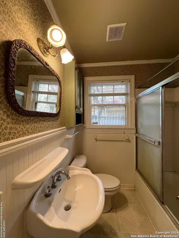 a bathroom with a toilet sink and mirror