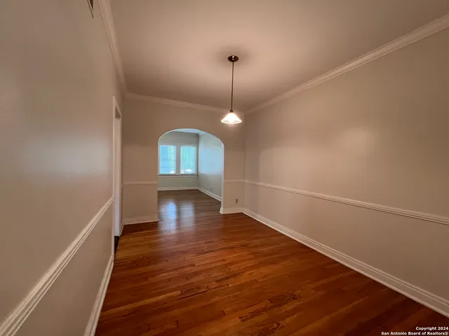 a view of a room with wooden floor and chandelier