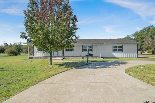 a view of a house with backyard and tree