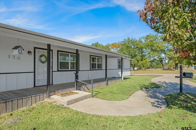 a view of a house with backyard and a tree
