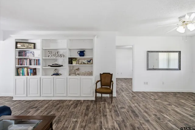 a living room with furniture and a book shelf